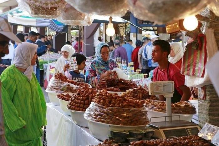 A vendor sells traditional cakes of fried honey and flour pastries to customers during the first day of Ramadan in the medina of the Moroccan city of Oujda June 18, 2015. REUTERS/Youssef Boudlal