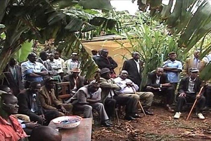 The shocked villagers at the site of the arson