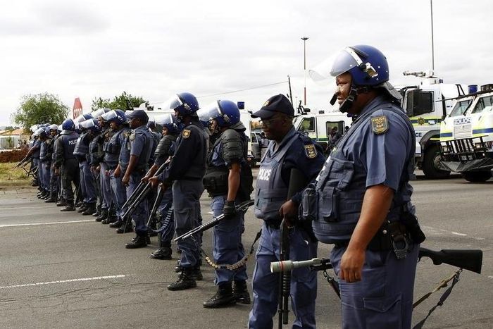 Police officers stand guard to prevent protesters from proceeding with their march in Rustenburg, South Africa's North West Province September 16, 2012. REUTERS/Siphiwe Sibeko