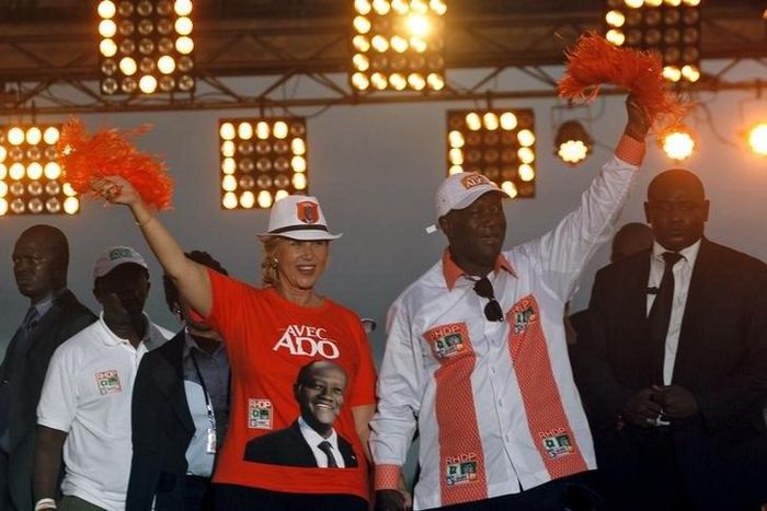 Ivory Coast's President Alassane Ouattara of the Rally of the Houphouetists for Democracy and Peace (RHDP) party and his wife Dominique Ouattara  wave during his last campaign rally , ahead of the October 25 presidential election, in Abidjan on October...