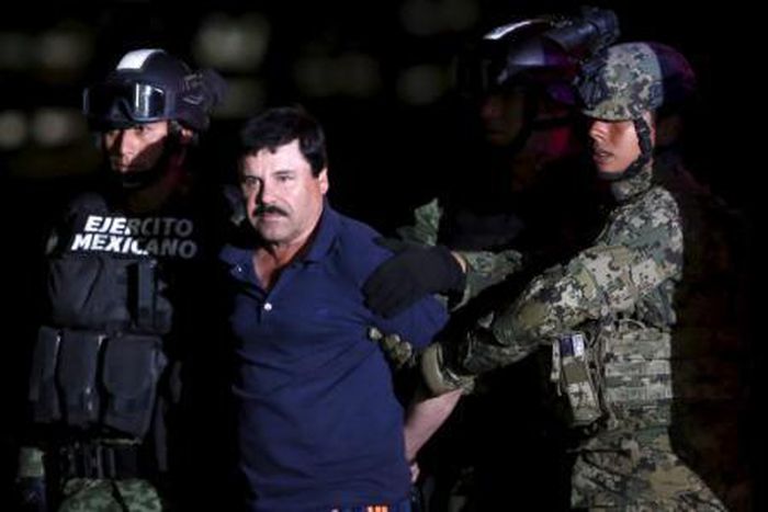 Joaquin "El Chapo" Guzman is escorted by soldiers during a presentation at the hangar belonging to the office of the Attorney General in Mexico City, Mexico January 8, 2016.