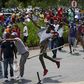 Students throw stones during a confrontation with security guards as they protest over planned increases in tuition fees outside the (UJ) University of Johannesburg October 22, 2015. REUTERS/Siphiwe Sibeko