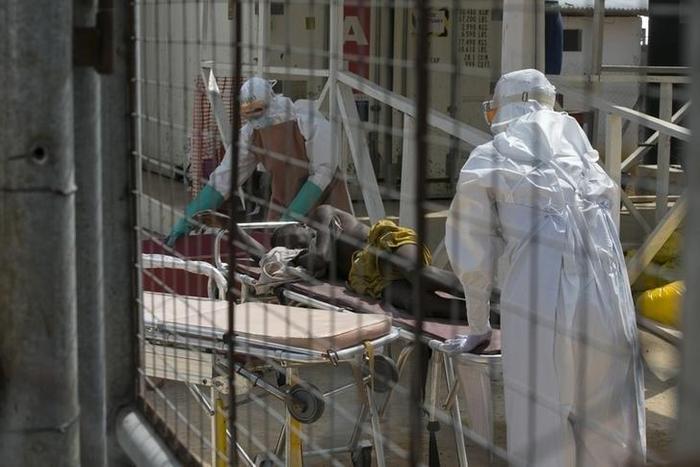 Health workers push a wheeled stretcher holding a newly admitted Ebola patient in a file photo. REUTERS/Baz Ratner