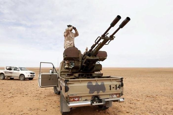 A Libyan soldier looks through binoculars at Wadi Bey, where troops are manning outposts, west of the Islamic State-controlled city of Sirte, February 23, 2016. REUTERS/Ismail Zitouny