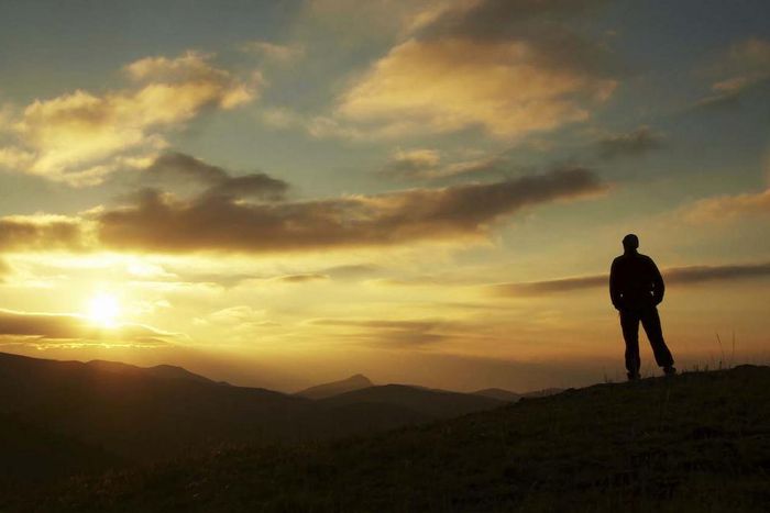 Male silhouette watching the rising sun
