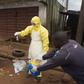 Health workers in protective equipment handle a sample taken from the body of someone who is suspected to have died from Ebola virus, near Rokupa Hospital, Freetown October 6, 2014.  REUTERS/Christopher Black/WHO/Handout via Reuters