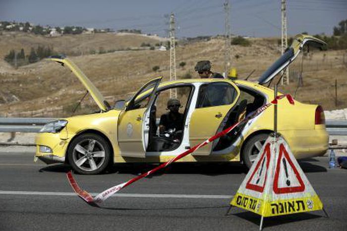 Israeli police explosives experts inspect a taxi at the scene of what police said was an attempted ramming attack near the West Bank Jewish settlement of Kfar Adumim November 22, 2015.