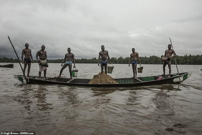 Cameroonian artisanal miners go diving in the Wouri river an average of 100 times a day for wet sand [Hugh Brown/SWNS.com]