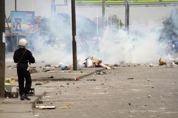 A policeman prepares to launch tear gas against protesters during a riot in a file photo.