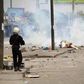 A policeman prepares to launch tear gas against protesters during a riot in a file photo.