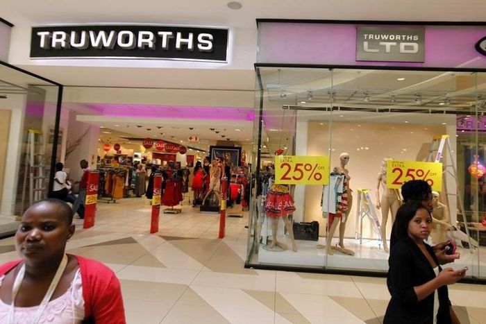 Shoppers walk past a Truworths shop with Sale advertisements on its windows at the Sandton shopping mall in Johannesburg January 30, 2012. REUTERS/Siphiwe Sibeko
