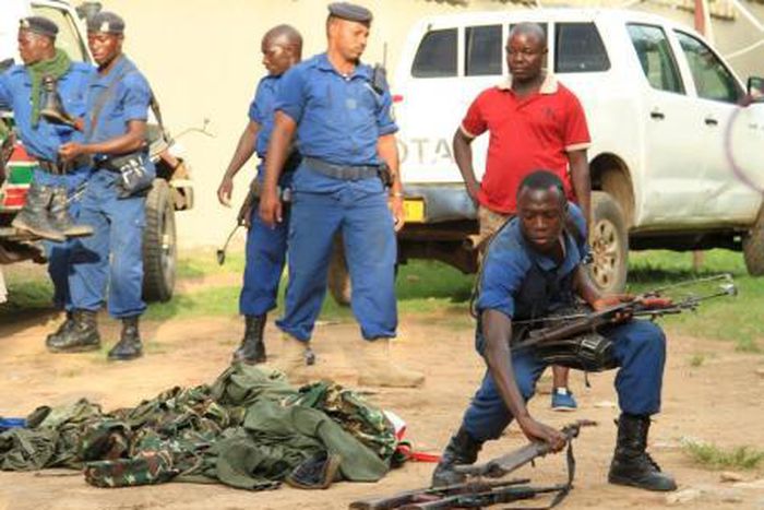 Burundian police officers collect a cache of weapons recovered from suspected fighters after clashes in the capital Bujumbura, Burundi December 12, 2015.