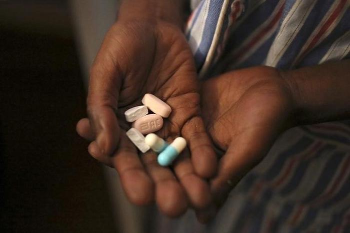Nine-year-old Tumelo shows off antiretroviral (ARV) pills before taking his medication at Nkosi's Haven, south of Johannesburg November 28, 2014. REUTERS/Siphiwe Sibeko
