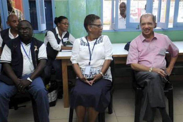 Seychelles President James Michel (R) talks to lawyer Alexia Antao at a voting centre during the presidential polls in Victoria, Seychelles, December 3, 2015.