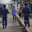 A woman passes by policemen during a protest against Burundi President Pierre Nkurunziza and his bid for a third term in Bujumbura, Burundi, June 2, 2015. REUTERS/Goran Tomasevic