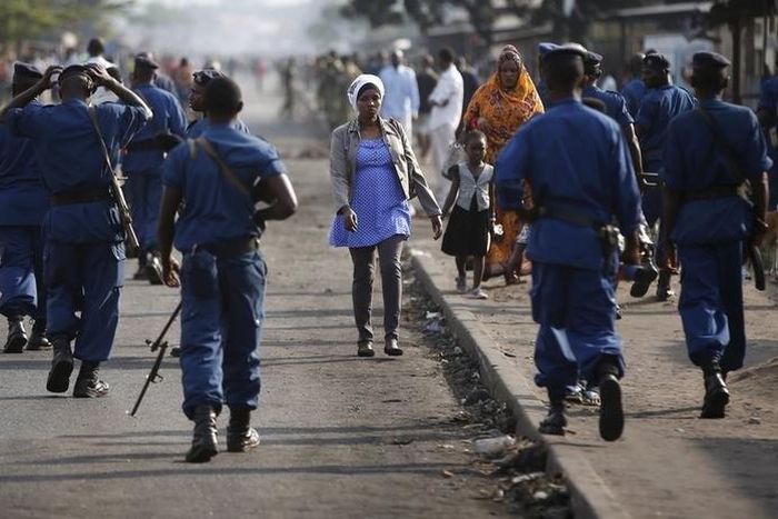 A woman passes by policemen during a protest against Burundi President Pierre Nkurunziza and his bid for a third term in Bujumbura, Burundi, June 2, 2015. REUTERS/Goran Tomasevic