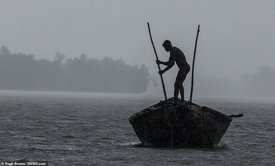 Cameroonian artisanal miners go diving in the Wouri river an average of 100 times a day for wet sand [Hugh Brown/SWNS.com]