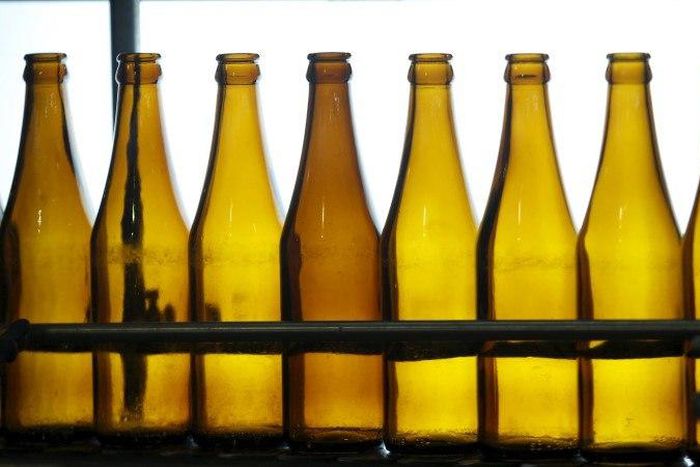 A workers checks for faults on beer bottles moving along a production line in a factory of Saigon Beer Corporation (Sabeco) in Hanoi, Vietnam May 26, 2015. REUTERS/Kham