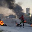 A Palestinian protester uses a sling to hurl stones towards Israeli troops during clashes, near Israel's Ofer Prison near the West Bank city of Ramallah December 25, 2015.