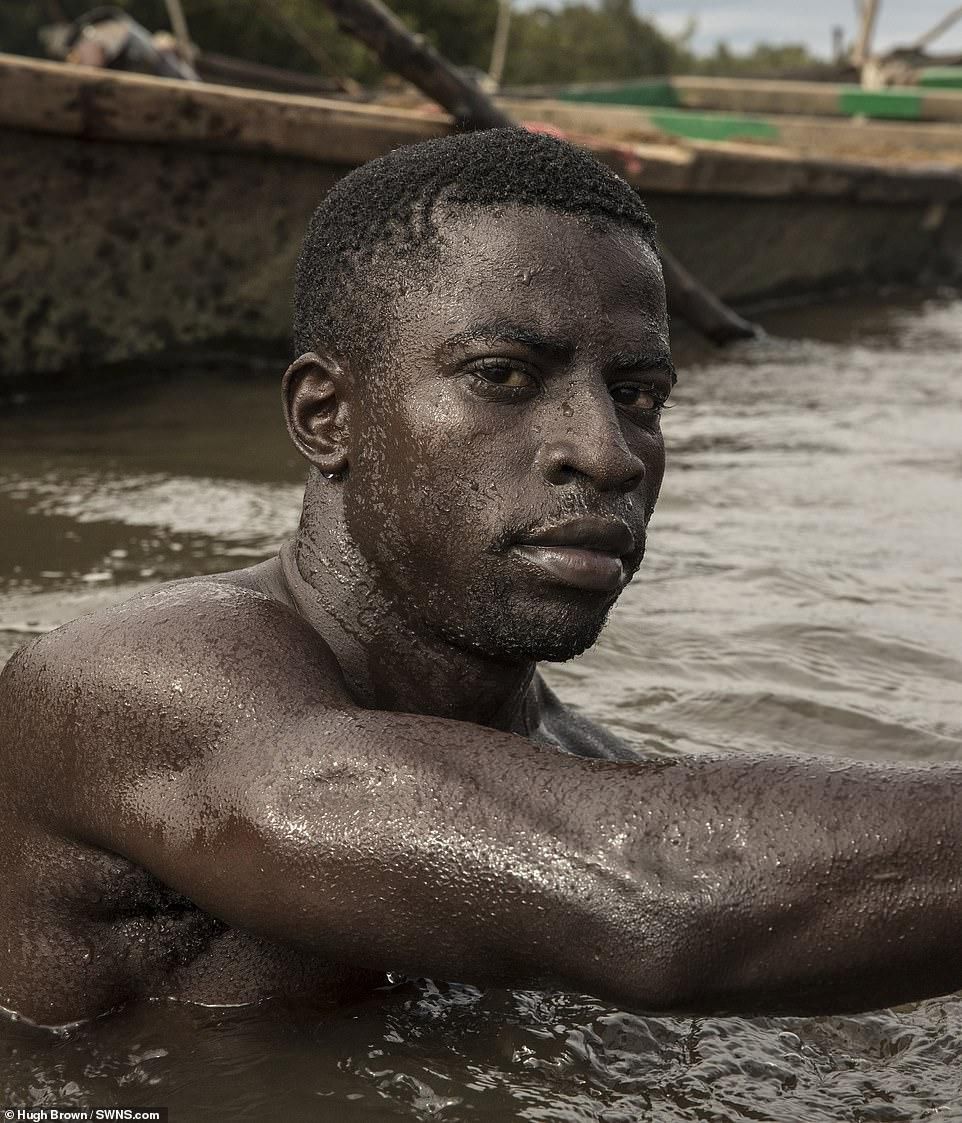 Cameroonian artisanal miners go diving in the Wouri river an average of 100 times a day for wet sand [Hugh Brown/SWNS.com]