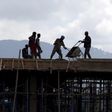 Construction workers work on the roof of a new building at the Mercato market in Addis Ababa September 11, 2015.