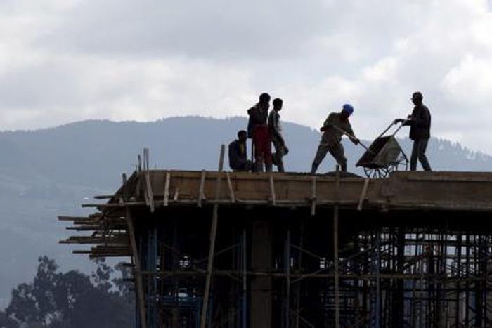Construction workers work on the roof of a new building at the Mercato market in Addis Ababa September 11, 2015.