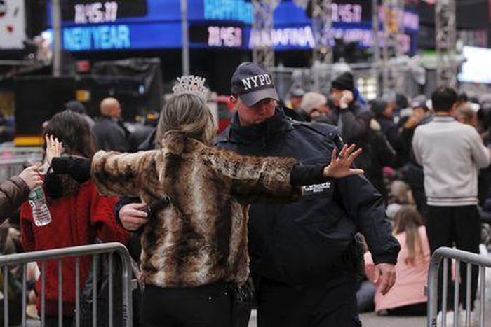 A woman is searched by a New York Police Department officer as she enters a pen to wait for the beginning.
