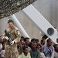 Migrants are seen aboard the British vessel HMS Enterprise before disembarking in the Sicilian harbour of Catania, Italy, October 6, 2015. REUTERS/Antonio Parrinello
