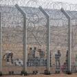 African would-be immigrants stand near the border fence between Israel and Egypt near the Israeli village of Be'er Milcha in a file photo. REUTERS/ Nir Elias