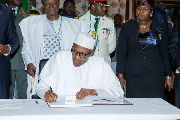 President Buhari signing the condolence register of the late Kerekou.