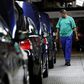 A worker walks near a row of cars at BMW's manufacturing plant in Rosslyn, outside Pretoria, September 13, 2010. REUTERS/Siphiwe Sibeko