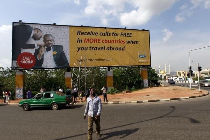A man walks in front of an advertisement billboard of MTN phone company in Abuja, Nigeria May 25, 2015.