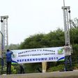 People erect a banner at the entrance of a polling station on the eve of a referendum as Rwandans will vote to amend its Constitution to allow President Paul Kagame to seek a third term in Rwanda capital Kigali, December 17, 2015.