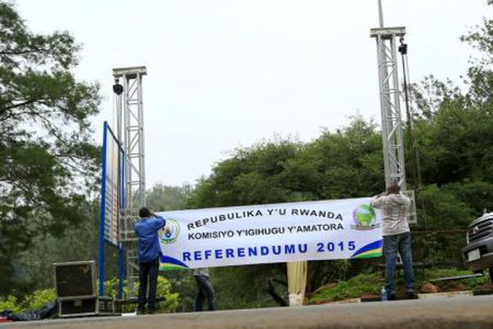 People erect a banner at the entrance of a polling station on the eve of a referendum as Rwandans will vote to amend its Constitution to allow President Paul Kagame to seek a third term in Rwanda capital Kigali, December 17, 2015.