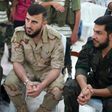 Zahran Alloush (C), commander of Jaysh al Islam, sits during a conference in the town of Douma, eastern Ghouta in Damascus, Syria August 27, 2014.