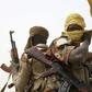 A Chadian soldier fixes his headscarf while driving at the front line during battle against insurgent group Boko Haram in Gambaru, February 26, 2015.   REUTERS/Emmanuel Braun