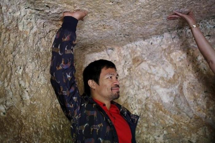 Filipino boxer Manny Pacquiao touches a ceiling during a visits to The Garden Tomb site outside Jerusalem's old city November 21, 2015. REUTERS/ Amir Cohen