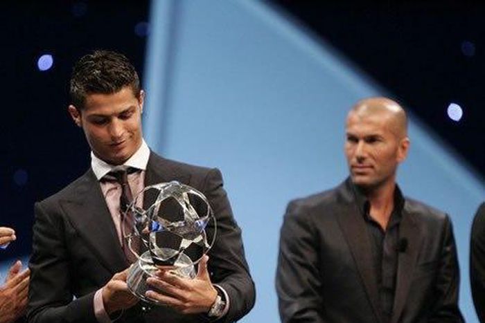 Cristiano Ronaldo receiving the UEFA Champions League award, with Zinedine Zidane behind him.