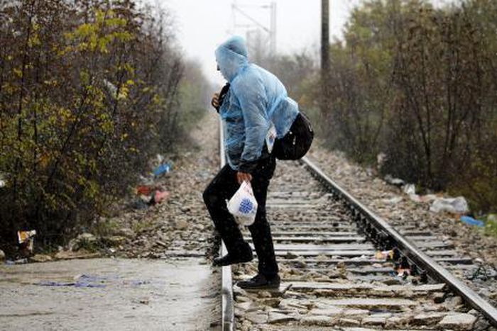 A Syrian refugee walks into Macedonia during a rainstorm after crossing the border from Greece to Macedonia near the Macedonian town of Gevgrelija November 27, 2015.