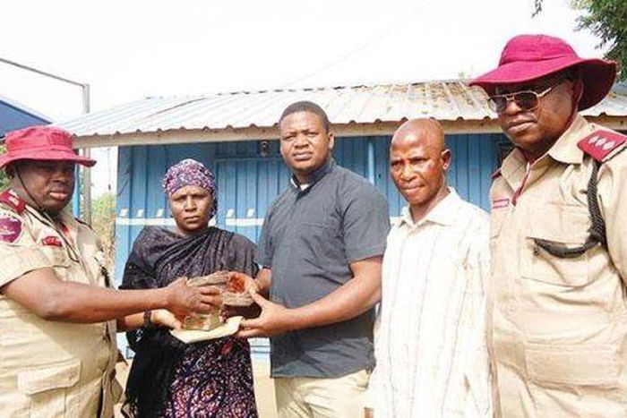 Acting unit head of operations, Yangoji unit command of the Federal Road Safety Corps (FRSC), Amadi Chika, left, handing the money over to the owners