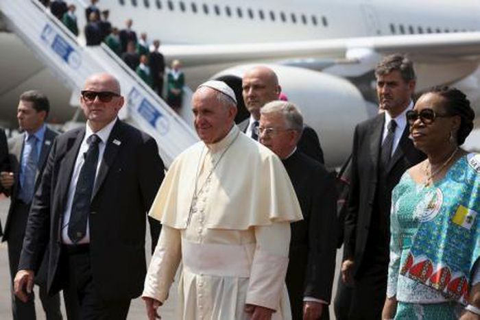 Pope Francis walks with the Central African Republic"s interim President Catherine Samba-Panza (R) after landing at the international airport of the capital Bangui, Central African Republic, November 29, 2015.