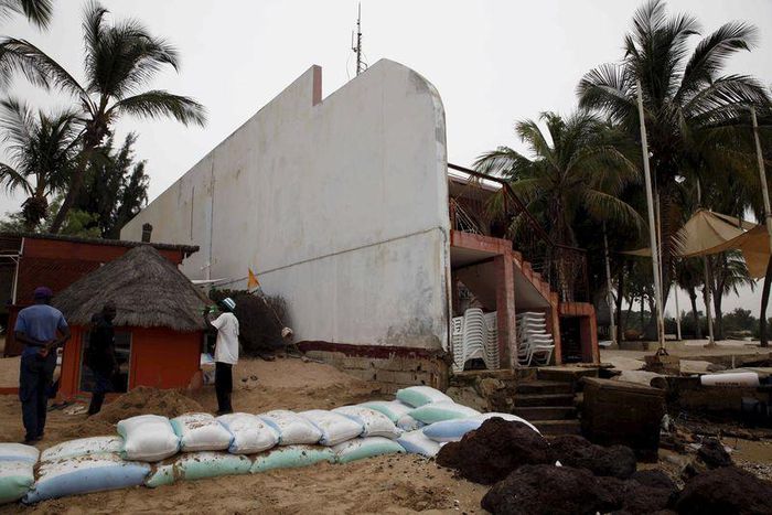 Hotel employees stand in front of sandbags protecting the hotel's beach in Saly, Senegal, November 12, 2015. To match CLIMATECHANGE-SUMMIT/AFRICA. REUTERS/Makini Brice