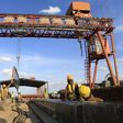 Workers are seen near a sign written in Chinese at the construction site of the Mombasa-Nairobi standard gauge railway (SGR) at Emali in Kenya October 10, 2015. Picture taken October 10, 2015. REUTERS/Noor Khamis