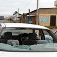 A car damaged by gunfire is seen abandoned as residents walk past bodies of unidentified men killed during gunfire, in the Nyakabiga neighbourhood of Burundi"s capital Bujumbura, December 12, 2015.