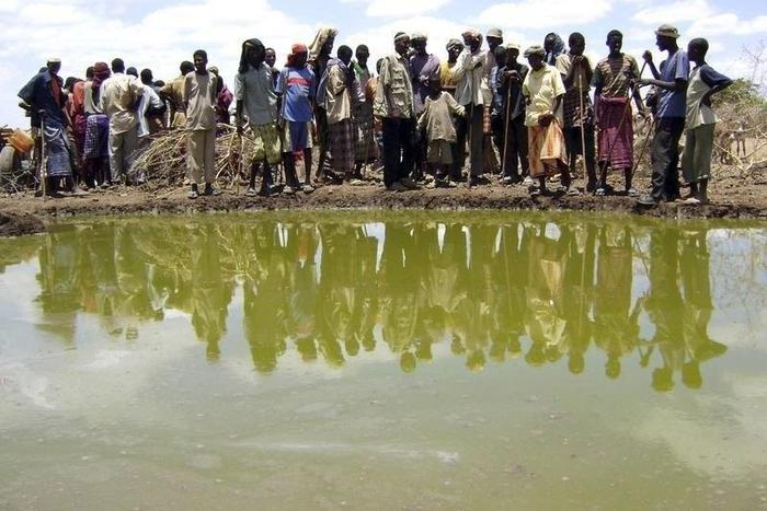 Residents gather to collect water at a contaminated reservoir in a file photo. REUTERS/Ismail Taxta