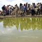 Residents gather to collect water at a contaminated reservoir in a file photo. REUTERS/Ismail Taxta