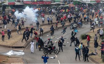 Protesters react amid clouds of tear gas fired by Kenya police officers during clashes at Saba Saba Day demonstrations in Nairobi on July 7, 2025. [SIMON MAINA/AFP via Getty Images]
