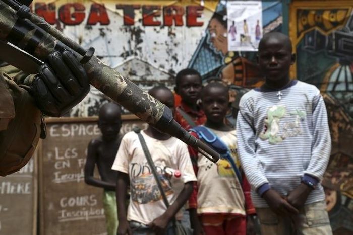 Children look at a soldier from the newly deployed EUFOR-RCA European Union military operation in the Central African Republic, patrolling along a street in Bangui May 8, 2014. REUTERS/Emmanuel Braun
