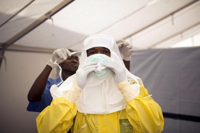 Health workers put on protective gear before entering a quarantine zone at a Red Cross facility in the town of Koidu, Kono district in Eastern Sierra Leone December 19, 2014. 
   REUTERS/Baz Ratner