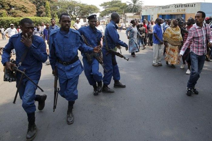 A protestor (R) jeers at policemen during Presidential election day in Bujumbura's Niyakabiga district, Burundi, July 21, 2015. REUTERS/Mike Hutchings